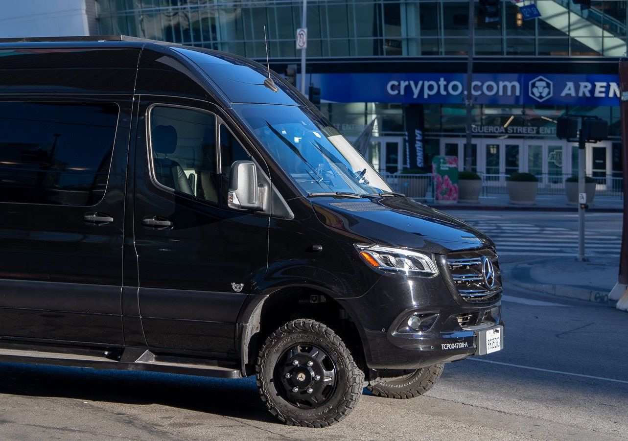 Black Mercedes van parked on city street.